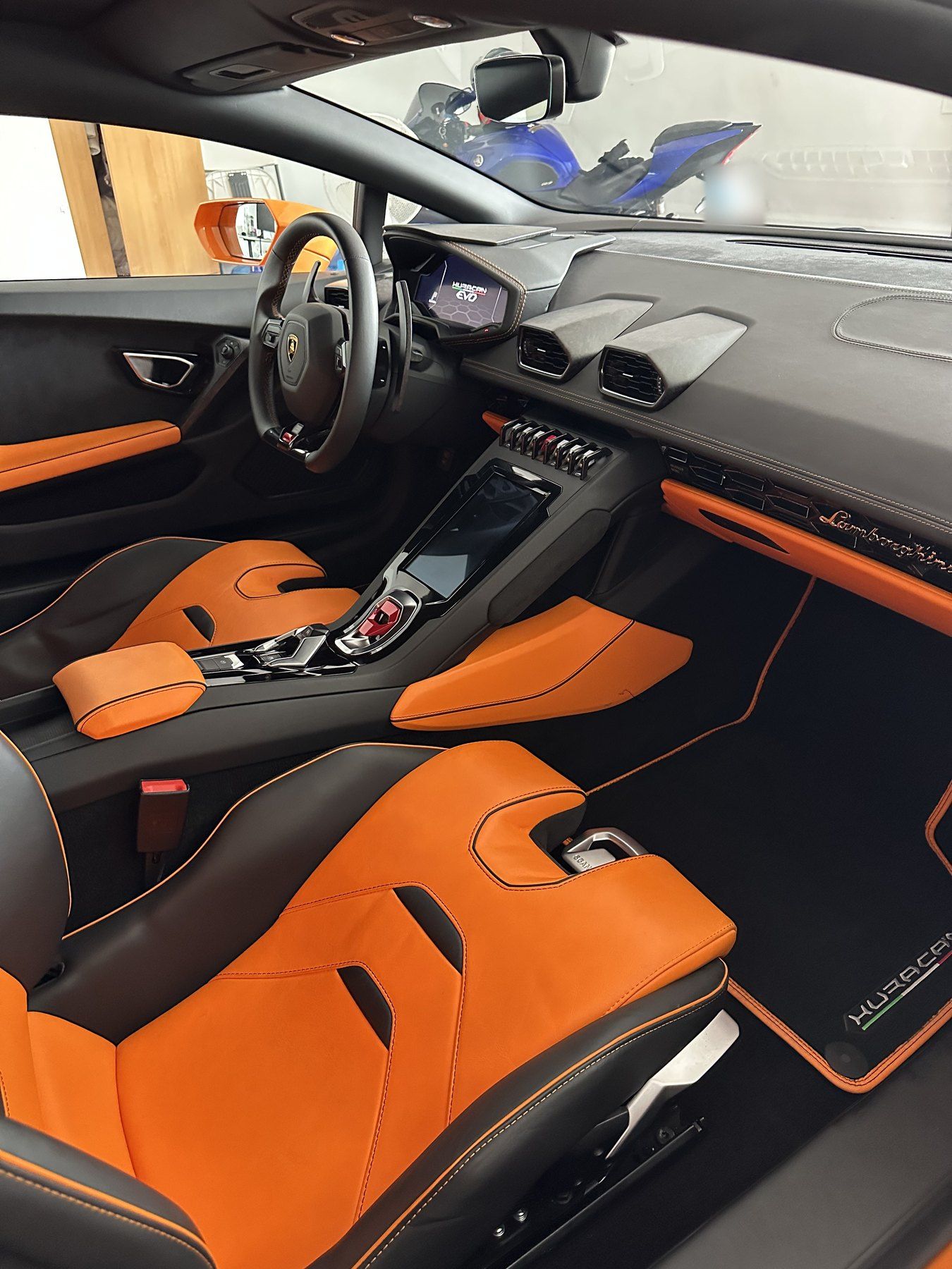 Interior de un Lamborghini con asientos naranjas limpio